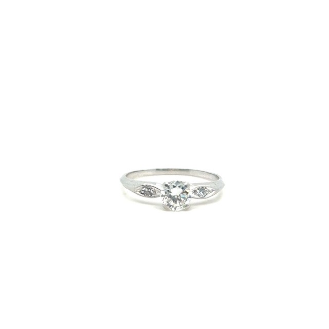 Platinum round brilliant diamond solitaire ring, approx. 0.73 ct I/VVS center stone, single-cut diamond accents in navette-profile cutout shoulders, plain polished shank, size 8.5