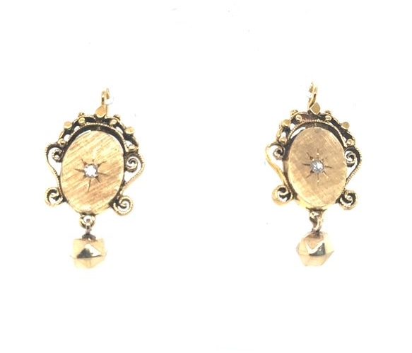 14K yellow gold French-cut diamond Victorian Etruscan Revival drop earrings, approx. 0.09 CTW starburst star-set diamond centers, brushed oval panels with scrollwork and granulation frames, approx. 6mm faceted gold ball drops, shepherd's hook wire backs, 6.65 grams