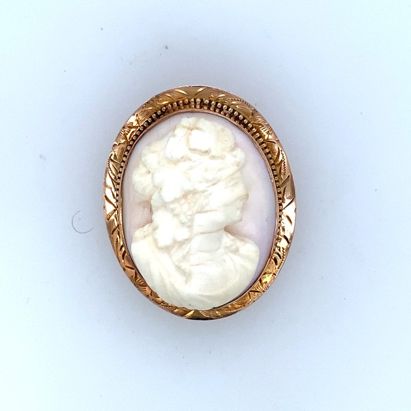 10K yellow gold shell cameo brooch, hand-carved female bust left-facing profile with upswept hair and floral adornment, engraved foliate frame with milgrain border, pin back, Art Deco, 1920s–1930s