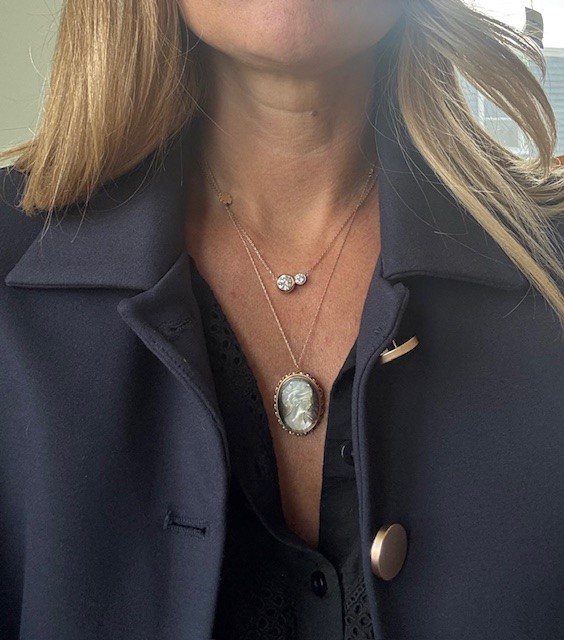 14K yellow gold carved mother-of-pearl cameo brooch/pendant, right-facing female bust with upswept hair and rose detail, dark contrasting ground, rope-twist and scalloped oval frame, hidden flip-up bail and pin back, approx. 1³⁄₁₆" x ¹⁵⁄₁₆", 3.5 grams, 1960s–70s