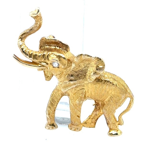 14K yellow gold figural elephant brooch with raised trunk, old mine cut diamond eye accent, approx. 0.05 ct, engraved fur-texture surface, pin back, 1¾" x 1½", 11.4 grams, 1970s–1980s