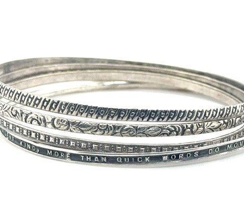 Sterling silver set of four bangle bracelets with floral, geometric, quatrefoil, and engraved literary quote designs, 18.4 grams total