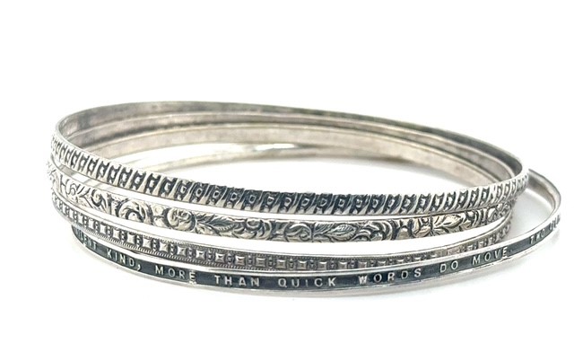 Sterling silver set of four bangle bracelets with floral, geometric, quatrefoil, and engraved literary quote designs, 18.4 grams total